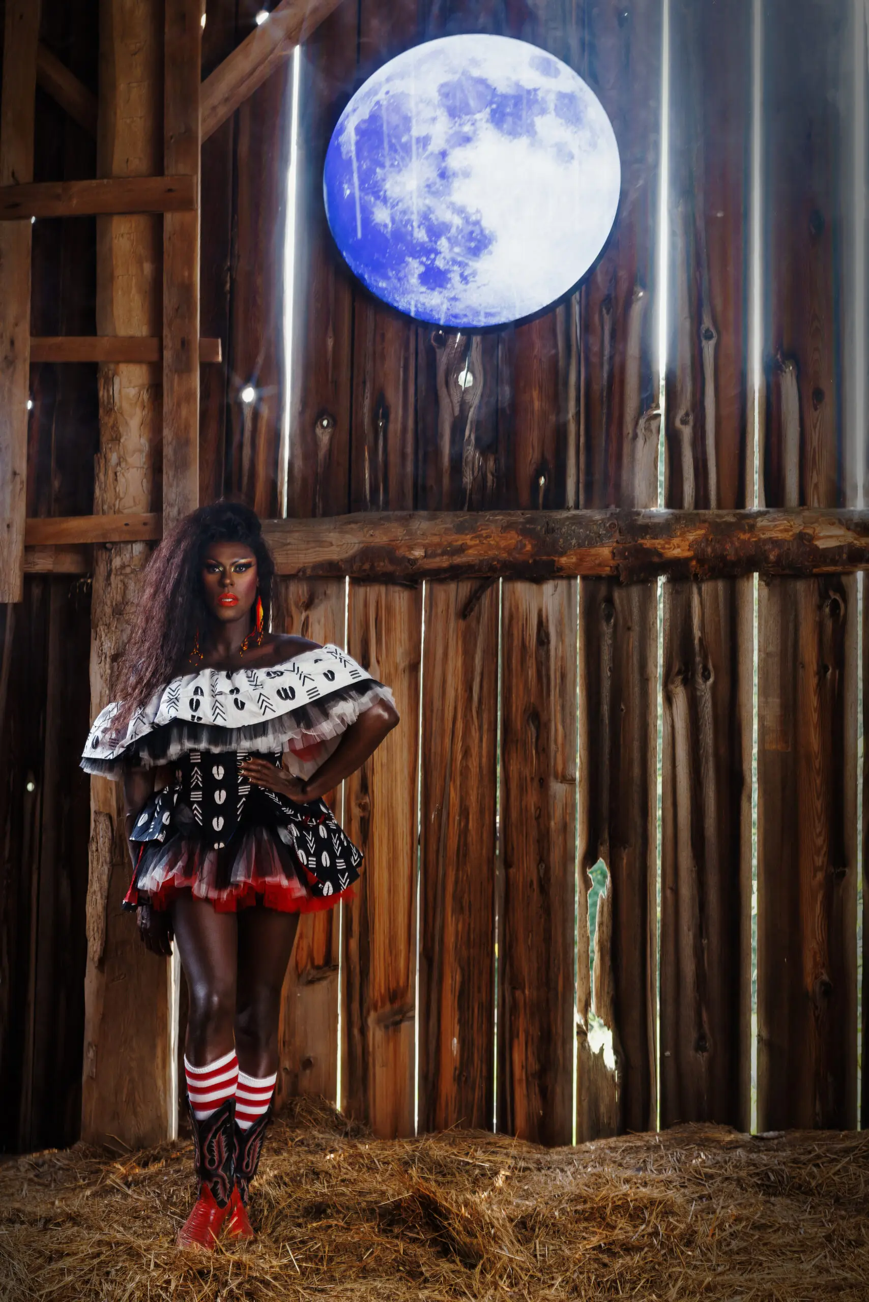 Love Masisi performing at THE SON beneath Shelley Niro's Pandemic Moon artwork