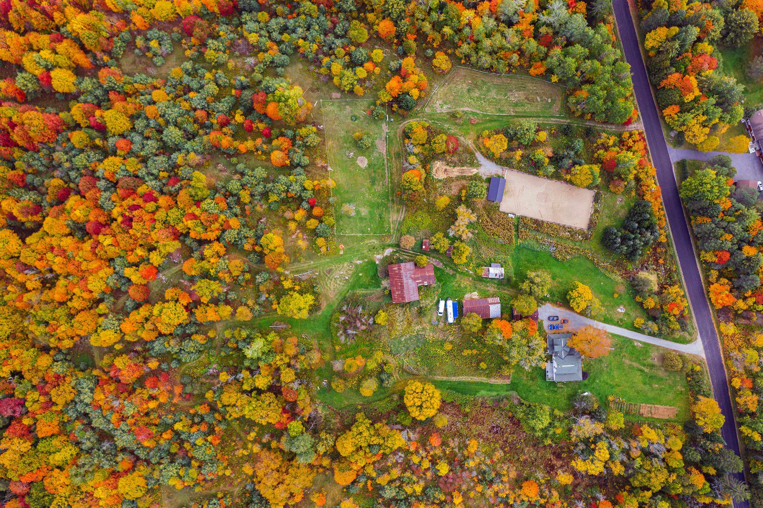 Aerial view of THE SON's 26.5 acres showing the barn, farmhouse and surrounding forest