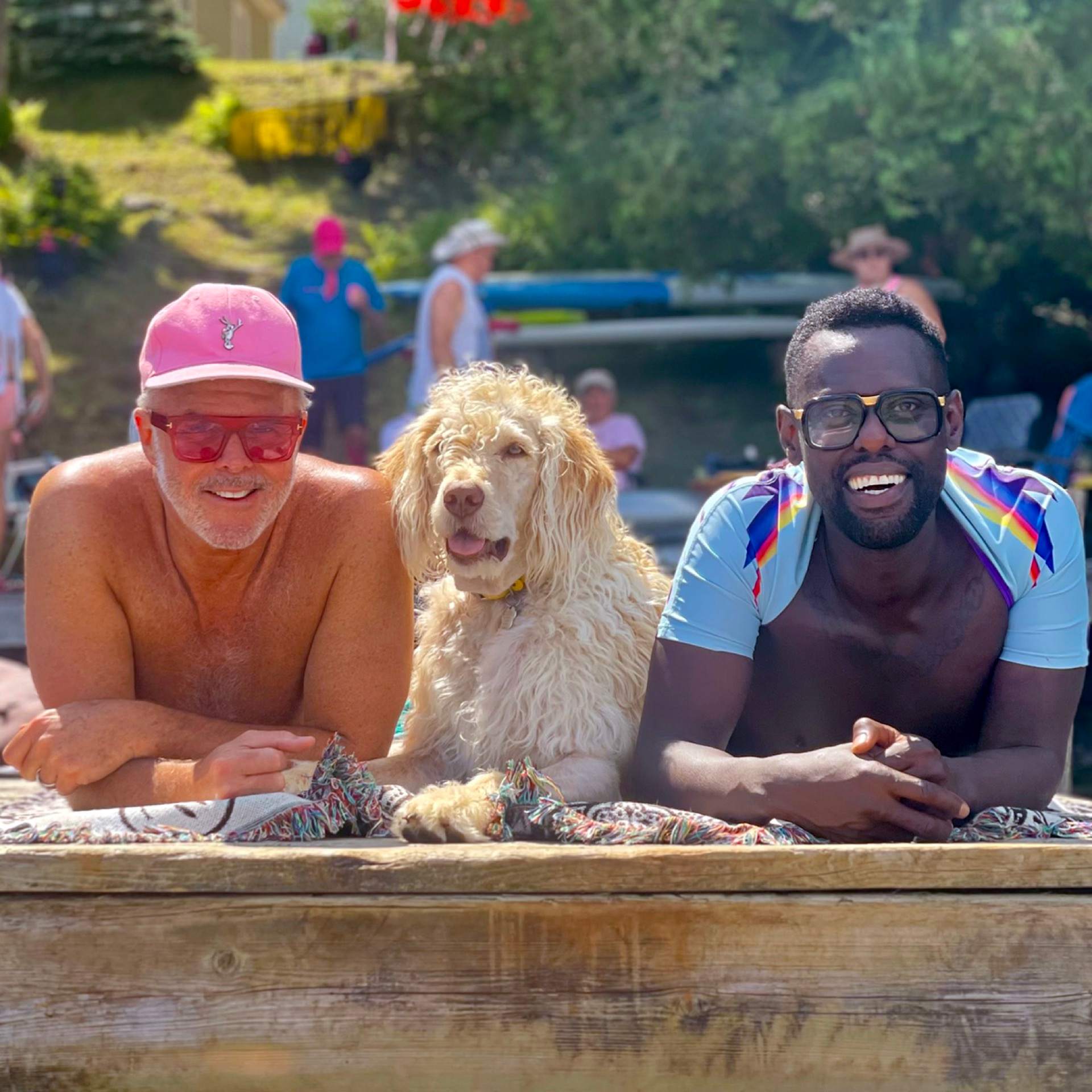 Barr Gilmore in a pink cap, Steve the dog, and Pierre Antoine Alexandre cooling off at the lake on a summer afternoon