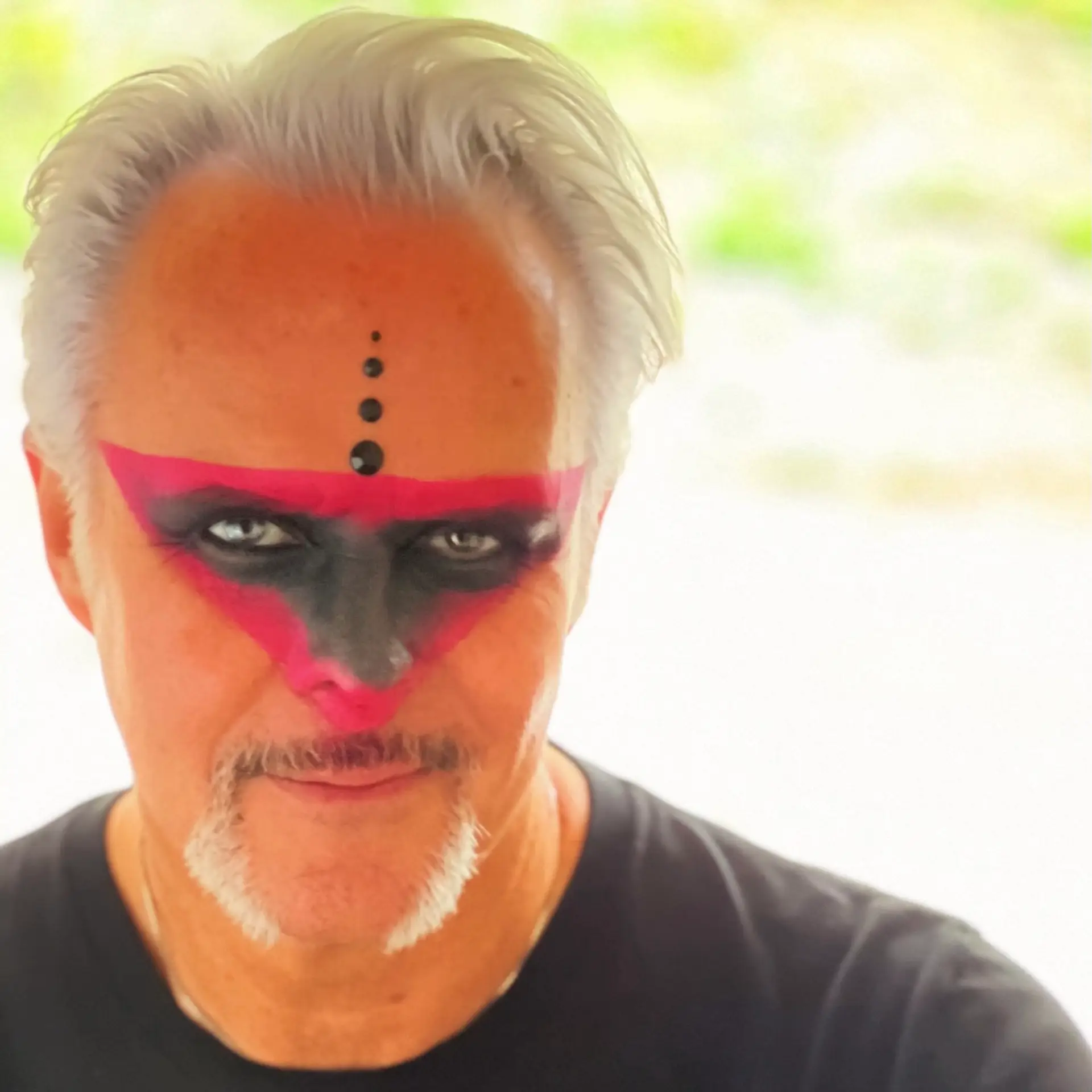 Close-up of Barr Gilmore wearing bold magenta and black face paint